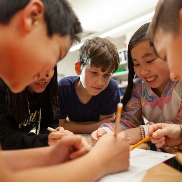 small group work Group of diverse children focused on a collaborative drawing activity.